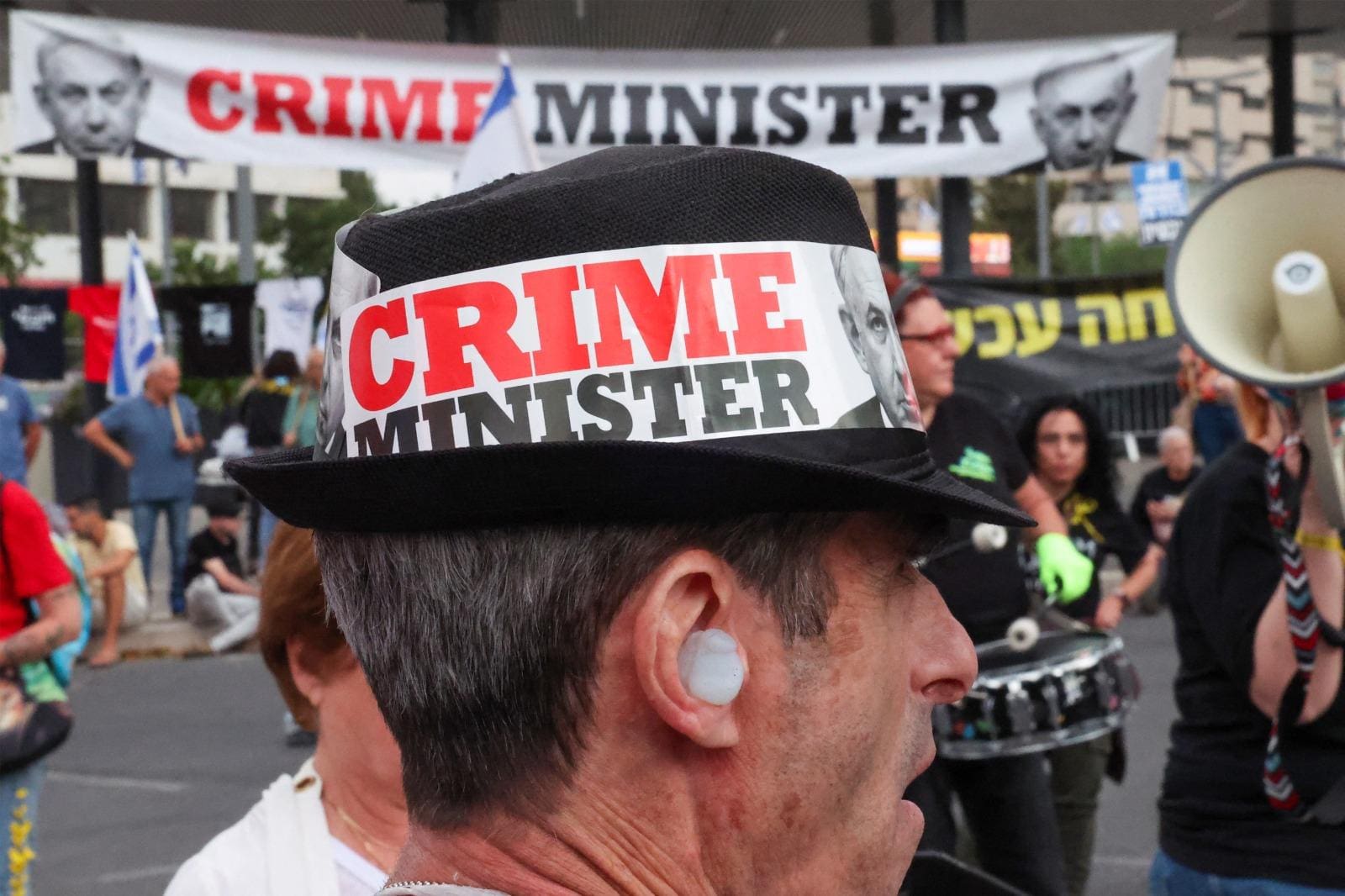 Um manifestante israelense usando um chapéu com um slogan contra o primeiro-ministro israelense, Benjamin Netanyahu